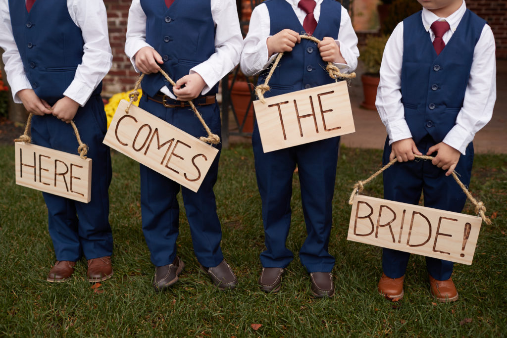 cute children holding here comes the bride sign. Photo by Vanessa Joy Photography.