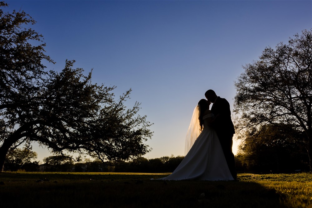 silhouette sunset portrait of bride and groom in garden. Photo by Vanessa Joy photography