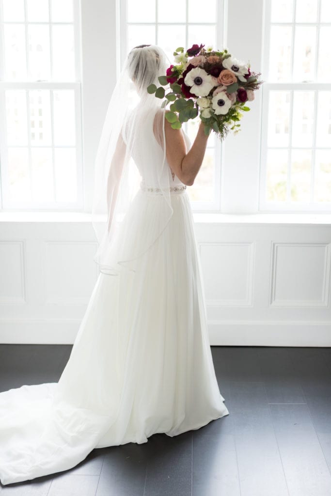 bride standing backwards holding Cassandra Shah Flowers and Event Design florals