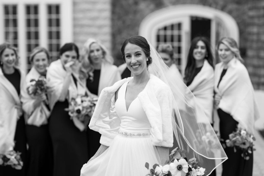 black and white photography of bride with her bridesmaids in the background
