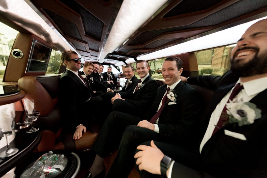 groom and his groomsmen laughing in the limo