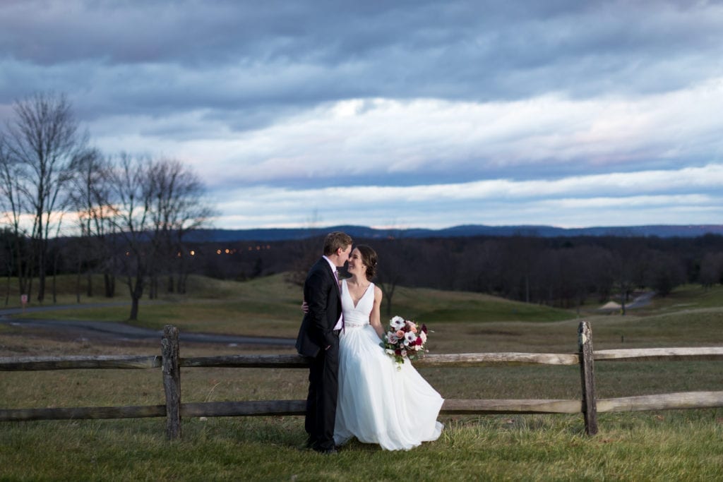 bride and groom in front of scenic countryside
