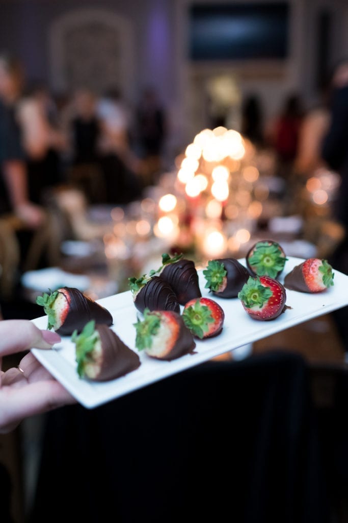 chocolate covered strawberries being handed out at wedding reception