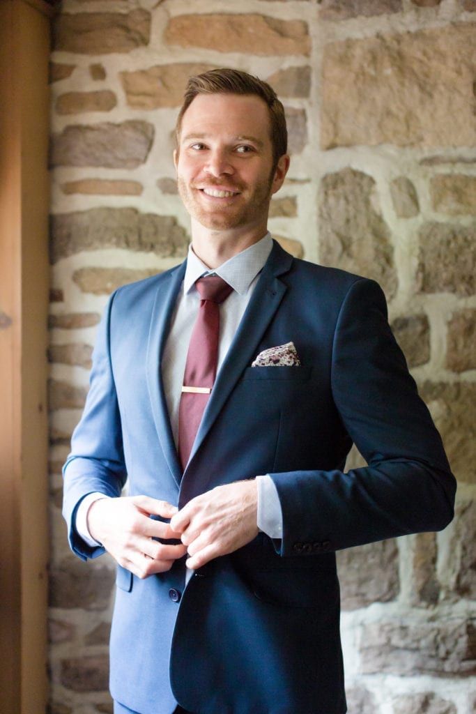 groom in his blue suit with maroon tie and floral handkerchief 