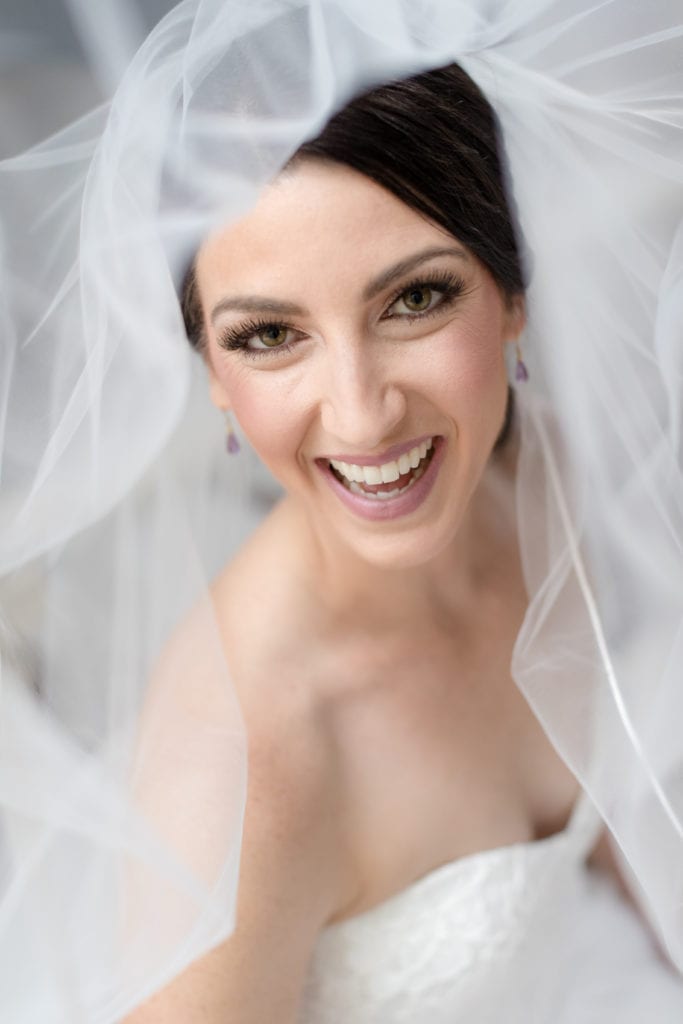bride smiling and showing off her beautiful makeup