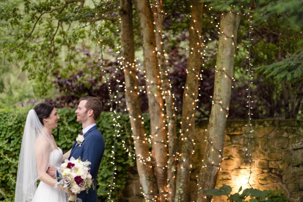 bride and groom in front of a lighted tree