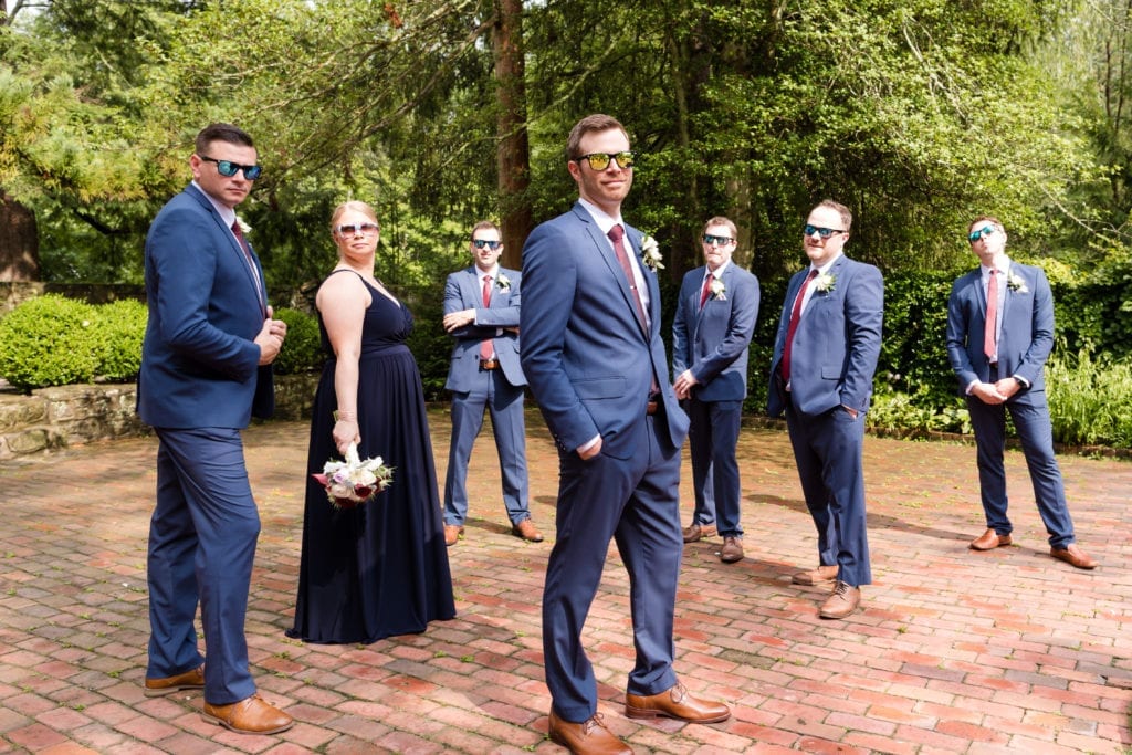 groom posing with his wedding party in fun sunglasses