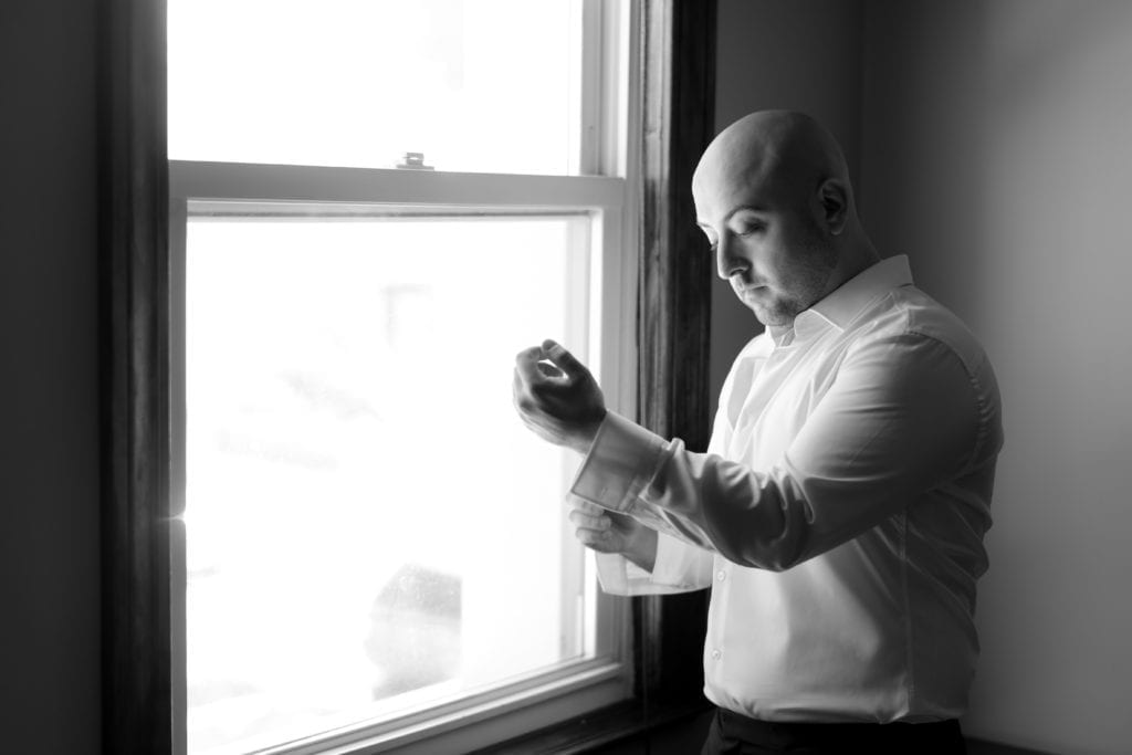 groom putting on his cufflinks for his wedding day