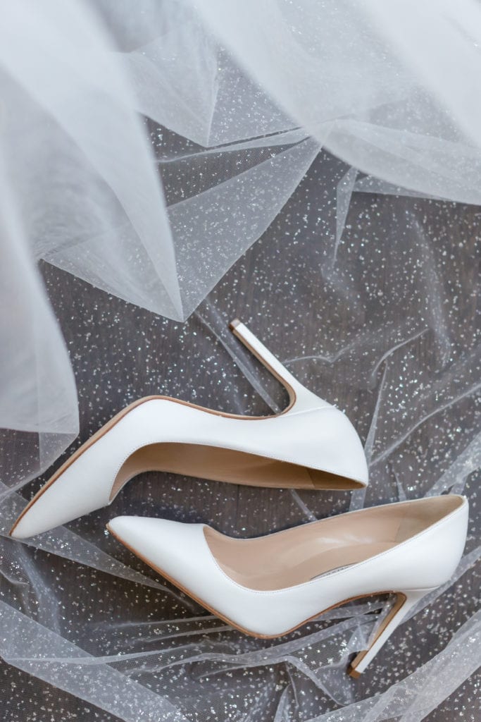 white manolo blahnik wedding shoes on brides veil