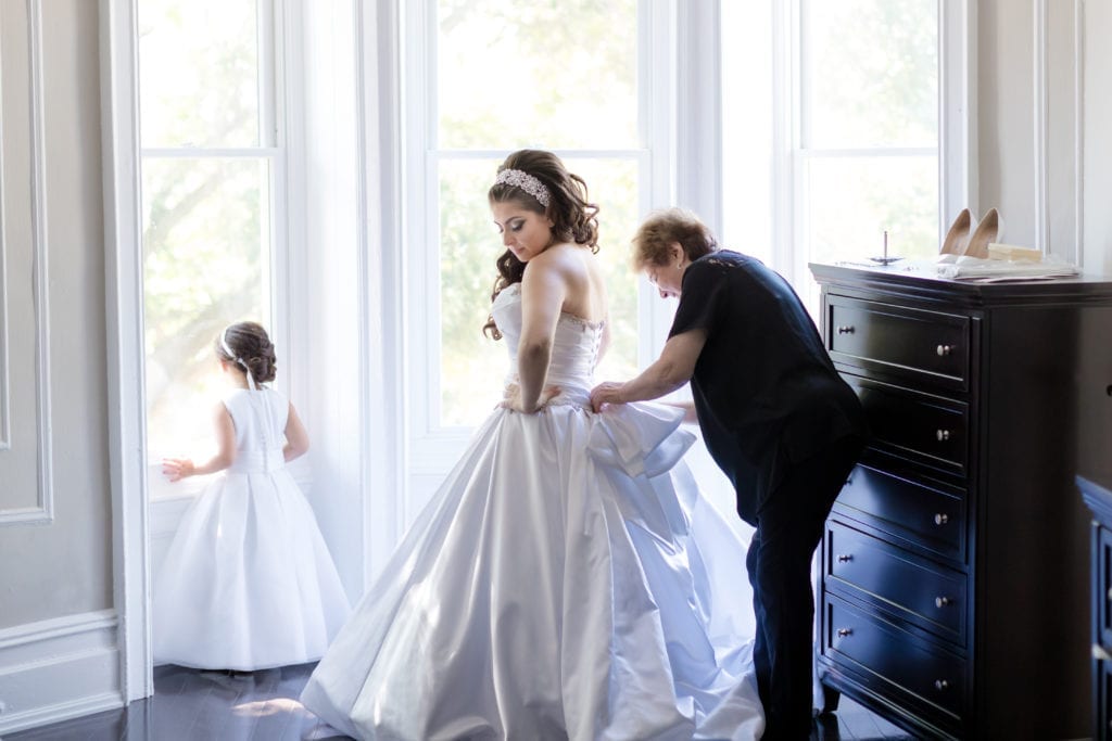 family of the bride helping her with her Pnina Tornai wedding dress