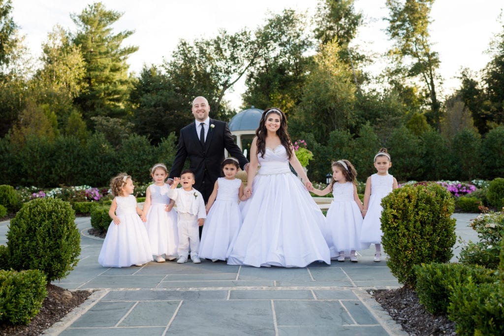 bride and groom surrounded by their many flower girls and ring bearer