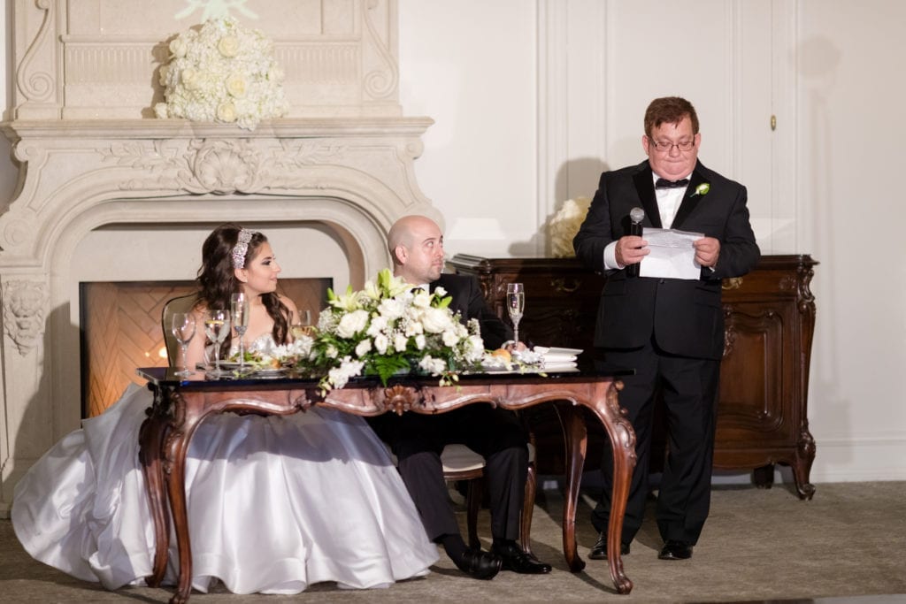 father of the bride reading a speech to his daughter at her wedding reception