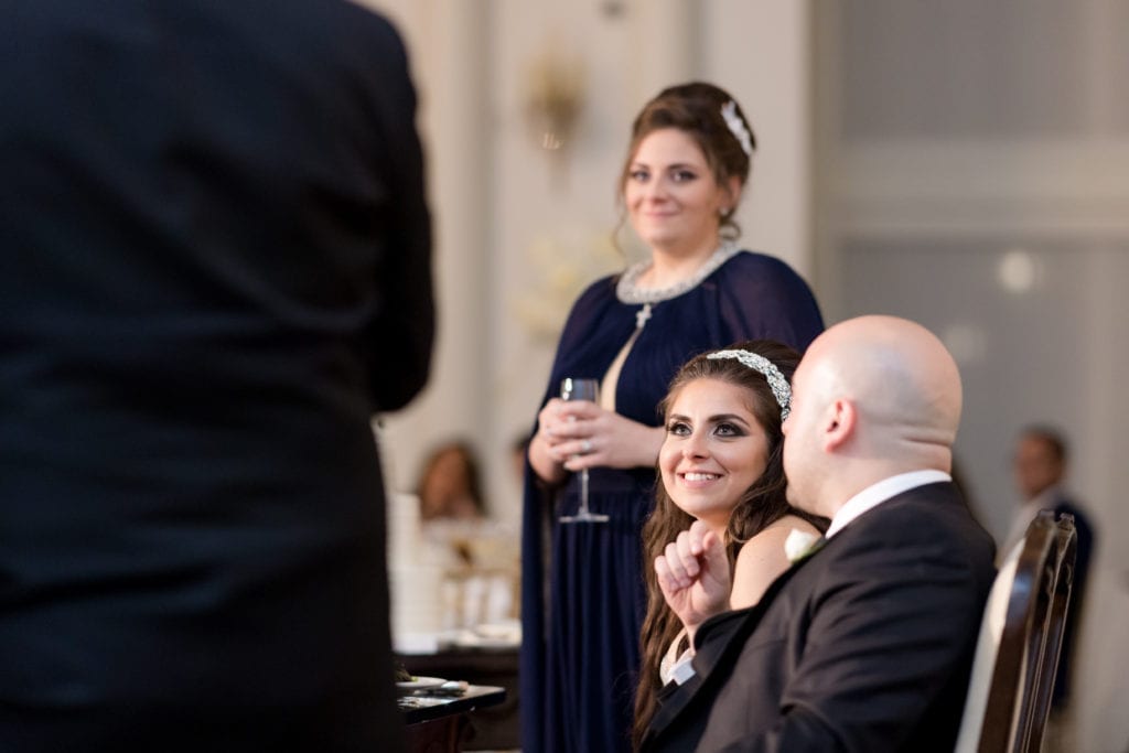 bride listening with a smile to wedding speeches