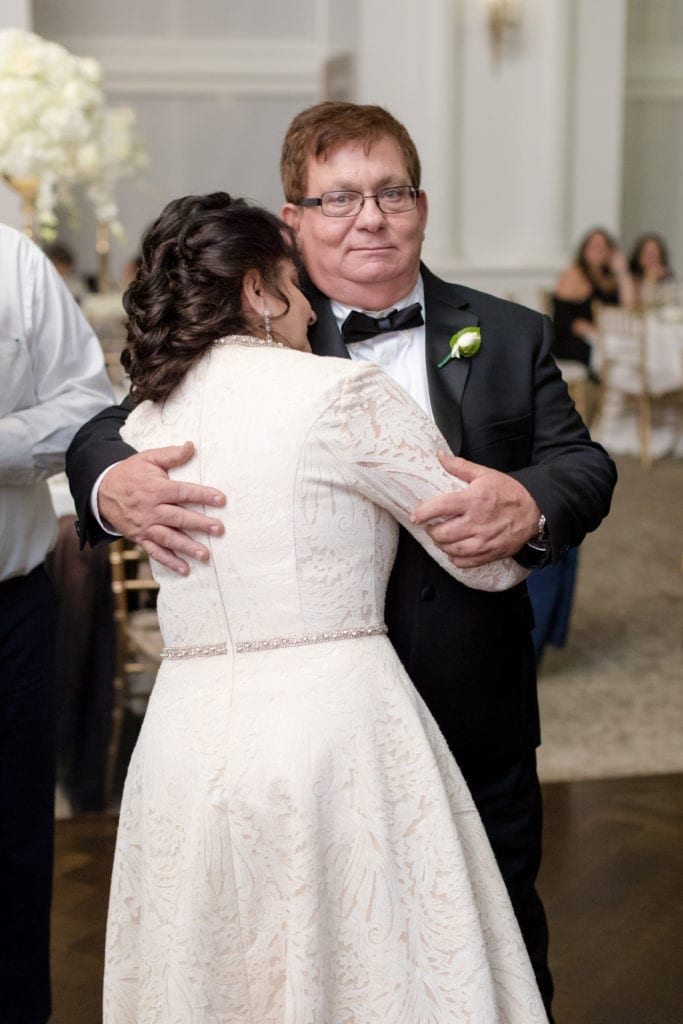 mother and father of the bride embracing for a dance