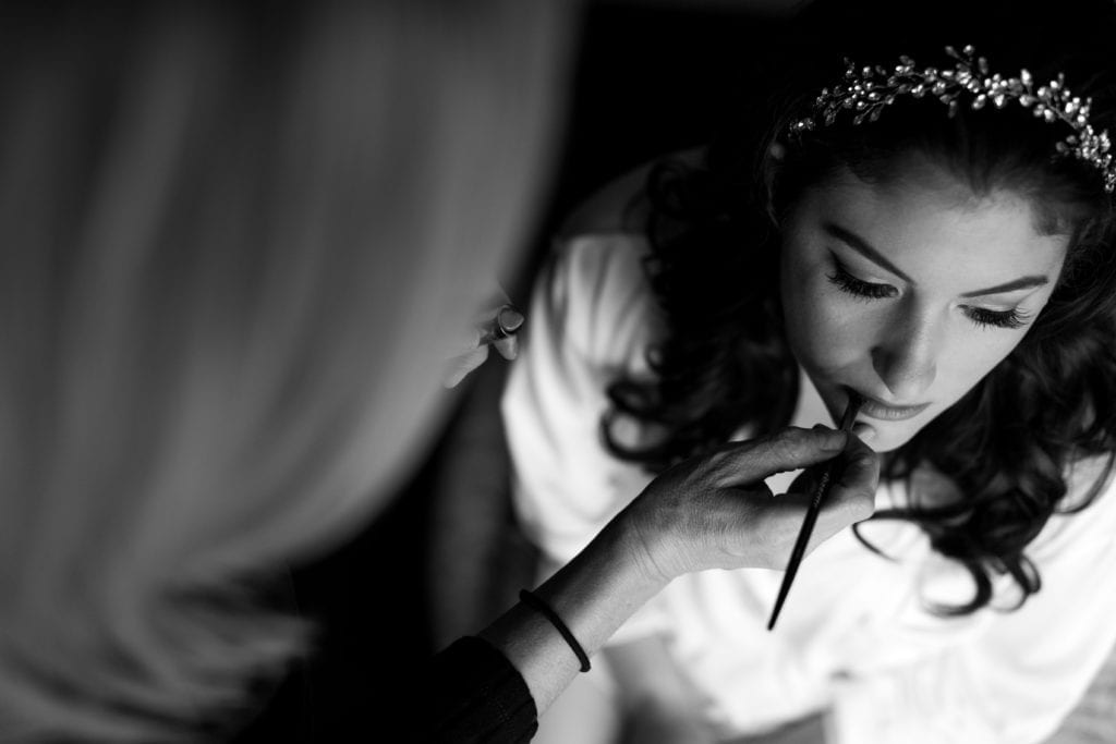 black and white image of the bride getting her lip makeup done