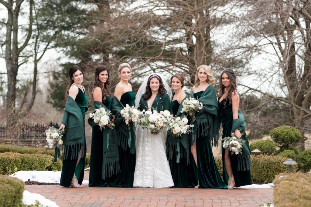 bride with her bridesmaid in her emerald green leather jackets and shawls