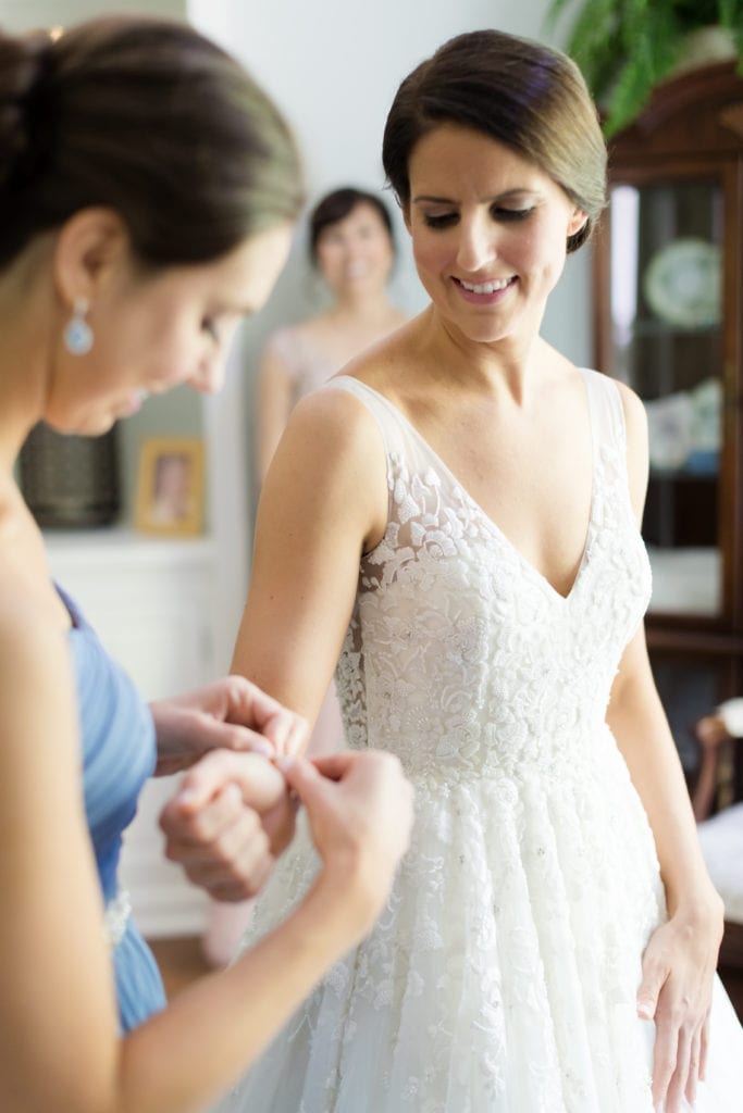 bride and bridesmaids getting ready, bride putting on jewelry