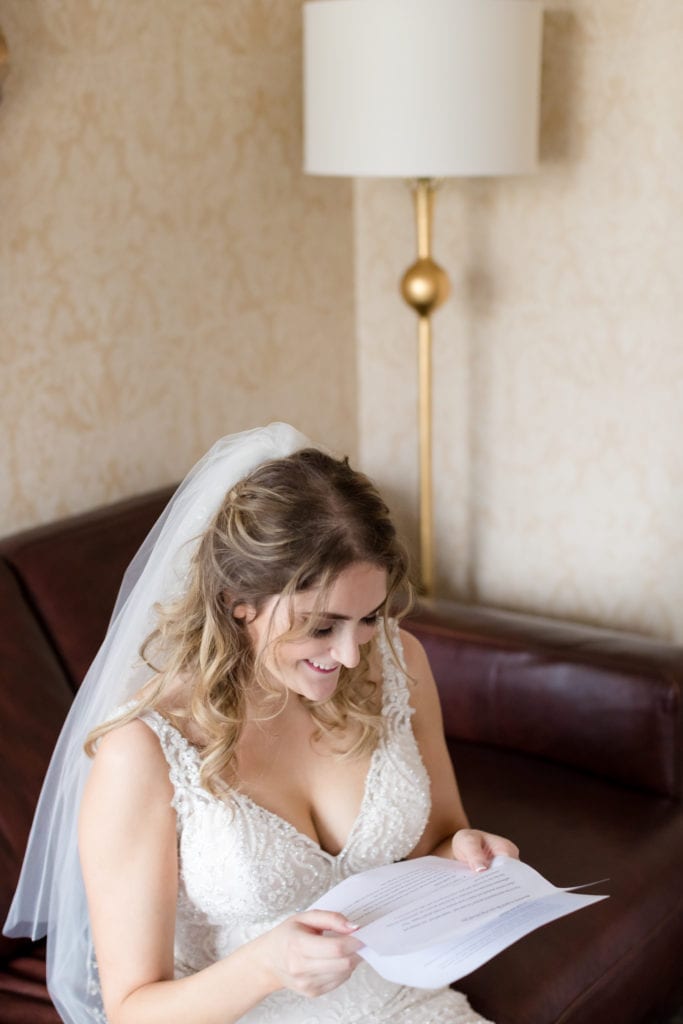 bride smiling while reading letter from her groom
