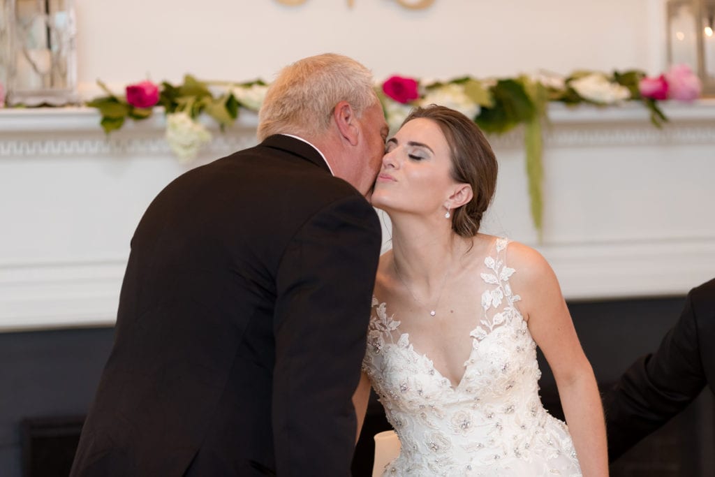 father of the bride giving her a kiss on cheek