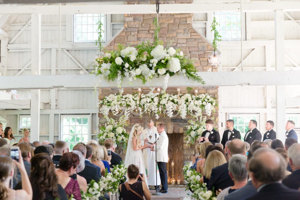 bride and groom at the alter, floral wedding arch