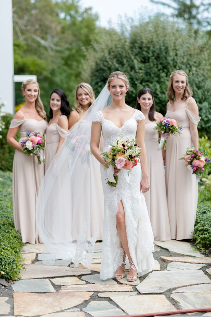bride in her Monique Lhuillier dress with bridesmaids in background
