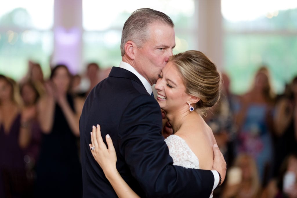 father embraces daughter at wedding