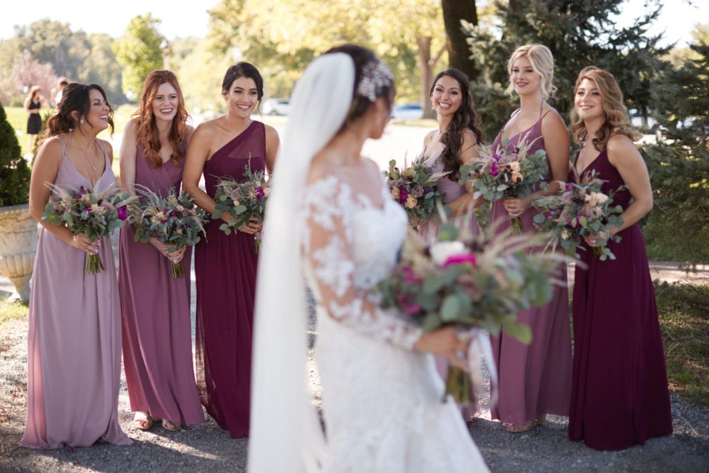 purple and plum bridesmaids dressing davids bridal, bride looking back at bridesmaids