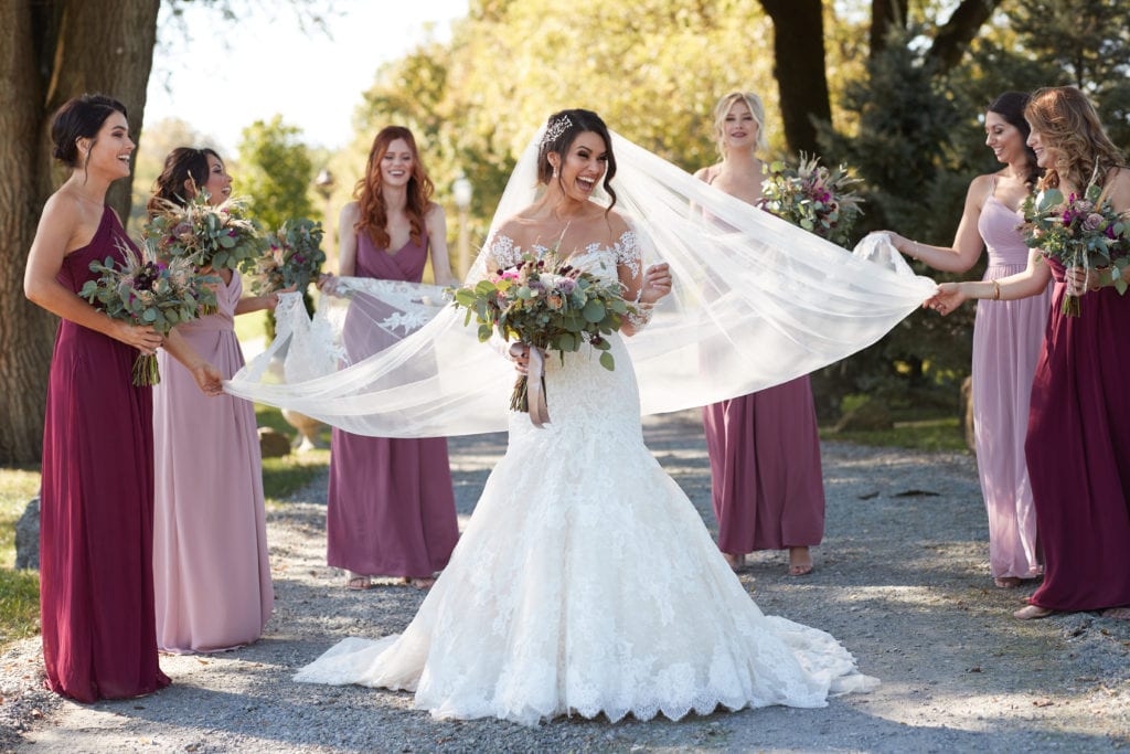 bridesmaids holding brides veil