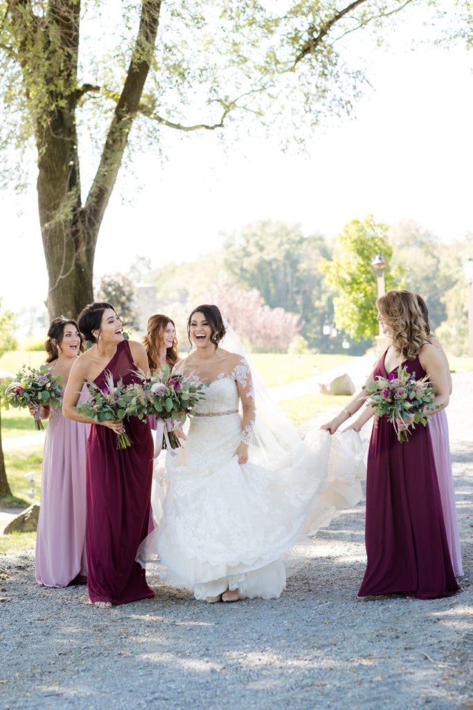 bridesmaids holding up brides dress