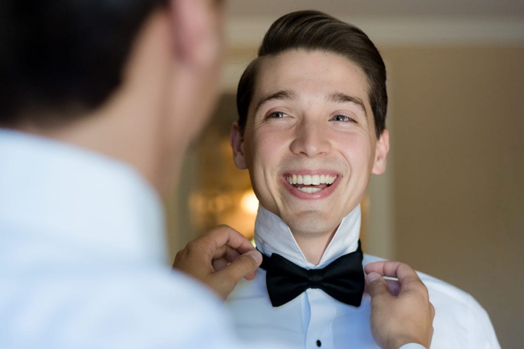 groom getting his bowtie put on