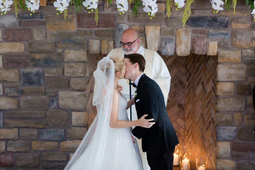 bride and grooms first kiss at their wedding ceremony