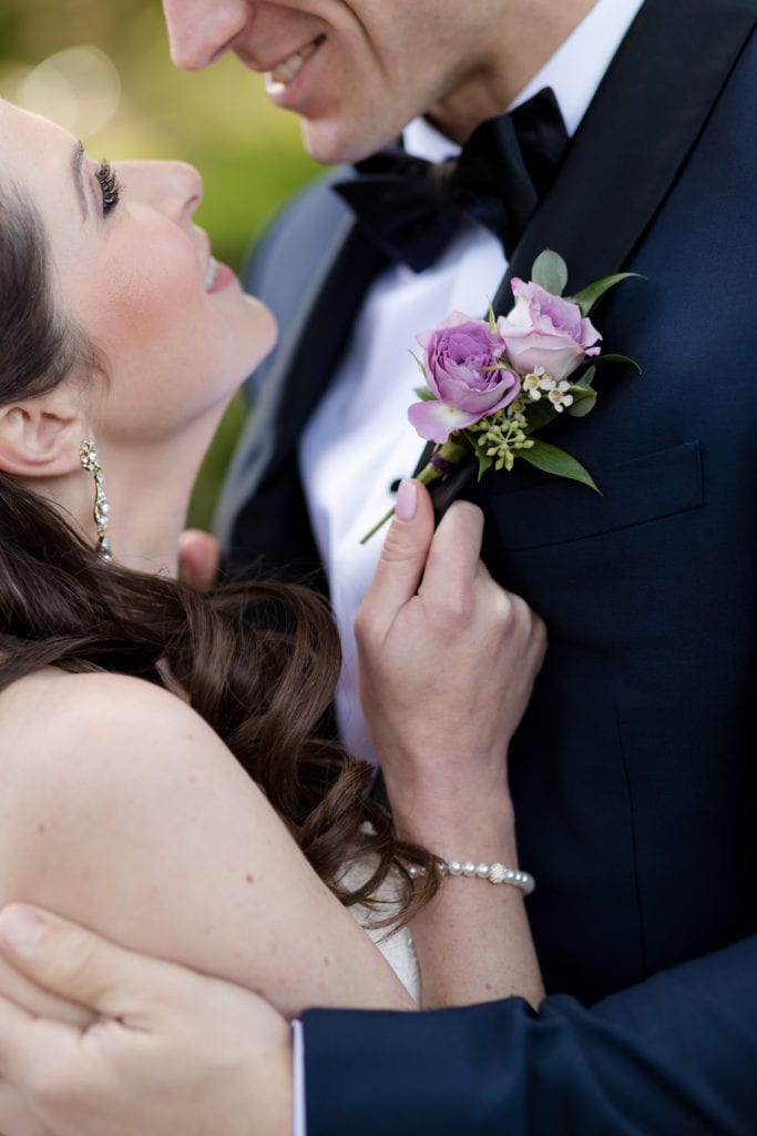purple rose boutonniere, bride embracing groom