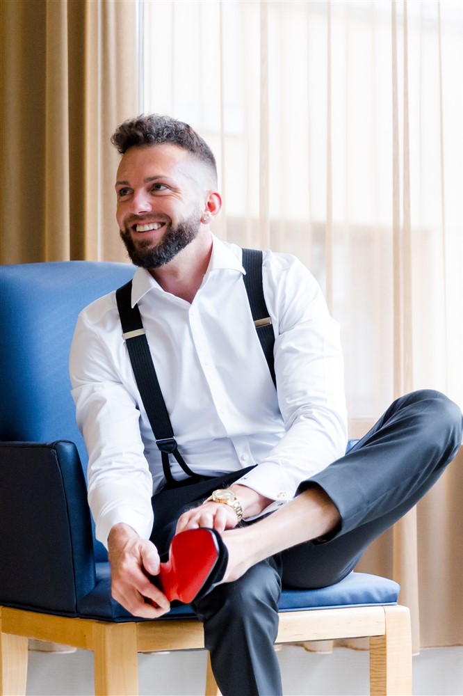 Portrait of groom getting ready with fancy Christian Louboutin shoes at luxurious hotel. Photo by Vanessa Joy Photography. 