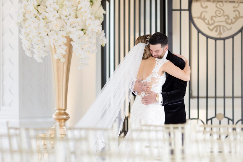 bride and groom hug on their first look at the wedding ceremony hall
