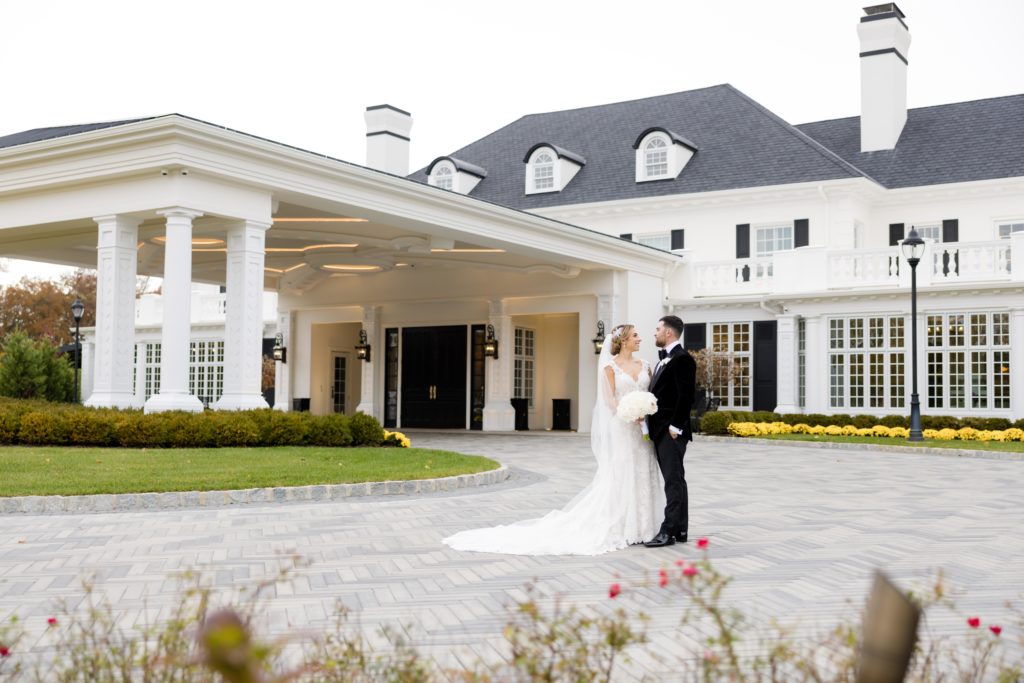 Bride and groom outside the mansion in Shadowbrook At Shrewsbury, Maggie Sottero Designs wedding gown, classic tux