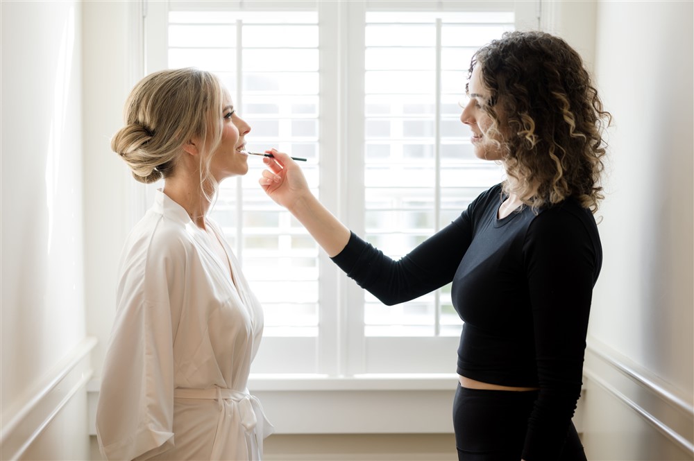 make up artist touching up bride's makeup
