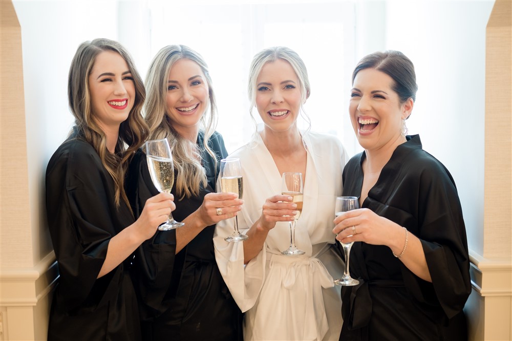 bridesmaids in robe toasting with champagne