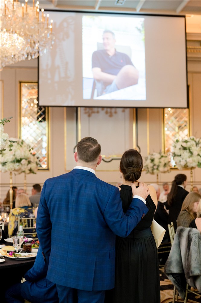 guests watching slideshow presentation at wedding