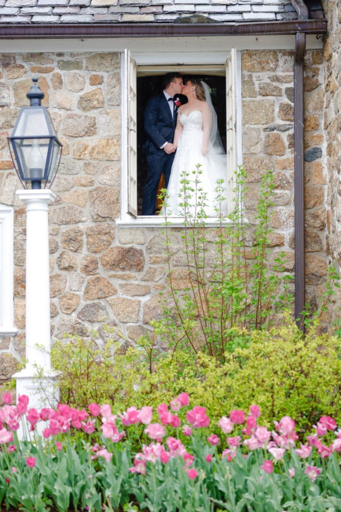 bride and groom in window spring flowers